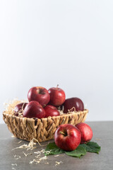 Ripe apples in basket on stone table, front view, gray background with copy space