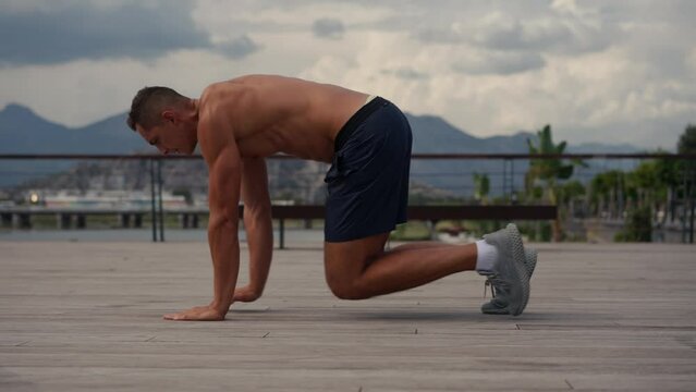Muscular athlete training crawling on the beach. Bear crawling exercise. Bodyweight training