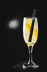 French 75 cocktail in a champagne flute on black background