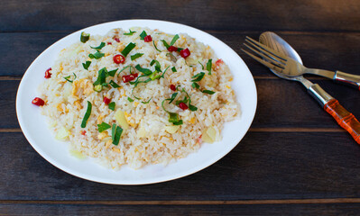 Fried rice on a dark wooden floor. Thai food. One dish appetizing cutlery.