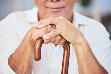 Old man hands, walking stick and disability from osteoporosis, arthritis and aging. Closeup of lonely, retirement and disabled senior widower with dementia, pain and wooden cane for support