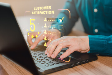 Businessman hand using computer laptop with popup five star icon for feedback review satisfaction service, testimonial. Customer service experience and business satisfaction survey.