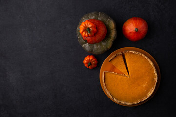 traditional pumpkin pie on black background, american recipe, jellied pie with condensed milk and cinnamon, october, autumn dish, homemade cake, thanksgiving, harvest, space for text, flat lay