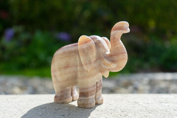Elephant statue near house in front of garden.