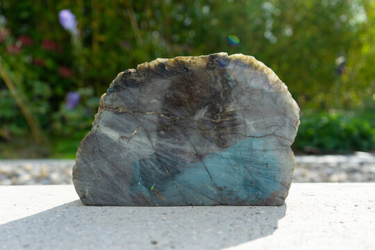 Labradorite mineral stone near house in front of garden.