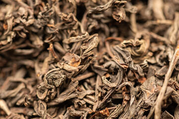 Large-leaved black tea in bulk on the table. Close-up of the surface texture