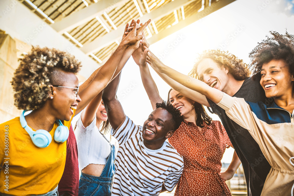 Wall mural multiracial happy young people stacking hands outside