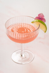 A pink cocktail drink with a splash droplet in the glass
