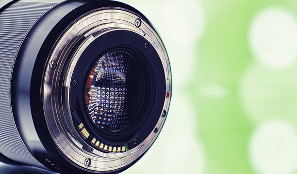 Equipment Videographer And Photographer. Lenses On The Table Against The Background Of Bright Lamps. Glare And Bokeh In Reflection Of Camera Glass.