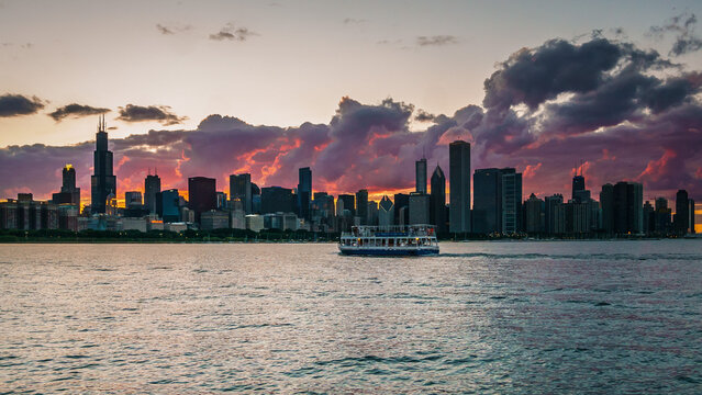 Chicago, IL - May 10 2022: The Chicago Skyline with a boat in the foreground during a colorful sunset