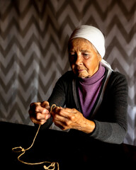 Elderly dame. Hands of old woman with polyarthritis disease. Canvas strings on fingers of elderly...