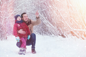 Young family with children are walking in the winter park. Winter walk of parents with children. Walking on a holiday weekend in the winter.