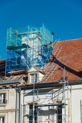 La restauration d'une vieille cheminée sur un vieux toit d'un ancien bâtiment historique. Un échafaudage sur une cheminée. Rénovation d'une cheminée