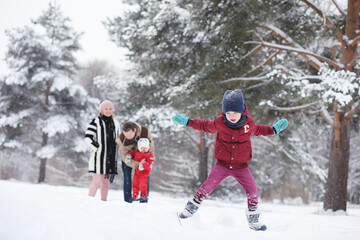 Young family with children are walking in the winter park. Winter walk of parents with children. Walking on a holiday weekend in the winter.