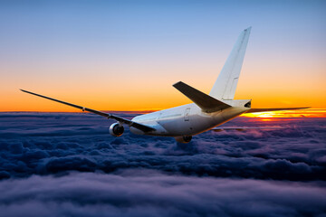 White wide body passenger airliner is flying in the sunset sky
