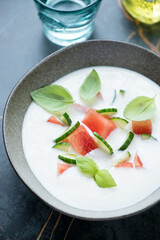 Close-up of cold summer soup made of sliced watermelon, cucumber and buttermilk, vertical shot, selective focus