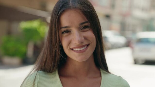 Young beautiful hispanic woman smiling confident standing at street