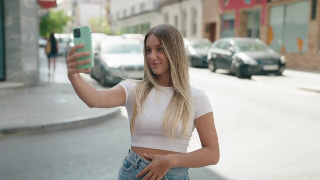 Young beautiful hispanic woman smiling confident making selfie by the smartphone at street