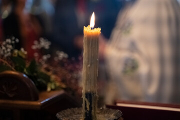 close-up of the fire on the yellow church candle in the church. Religious rituals with candles. Close-up of a candle in the church during the wedding.