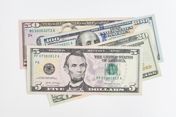 5, 20, 50, 100 dollars banknotes at different angles. Close up of dollars on white background.