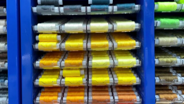 Sewing kit, multi colored thread spools in plastic packages in store, shop or supermarket.