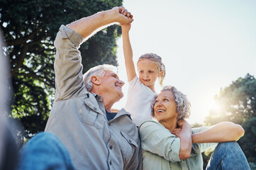 Grandparents playing together with a girl in the park in the morning. Family, love and grandchild...