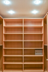 Wardrobe room in an apartment with wooden cabinets storing clothes.