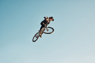 Fototapeta na wymiar Motorcycle stunt, man cycling in air jump on blue sky mock up for sports action performance, fitness training or outdoor bike performance. Professional sports person with bmx bicycle adventure mockup