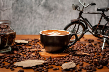 Kawa latte w filiżance na drewnianym stole pełnym świeżo palonych ziaren kawy
