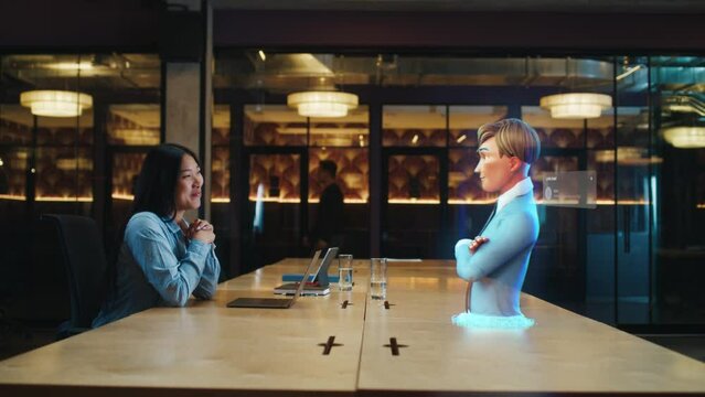 Video call chat conference of an asian woman using hologram technology. Conversing with a cartoon character avatar of young man. Advanced technology. VFX. Augmented reality.