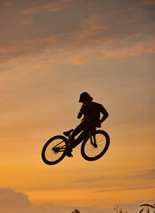 Fototapeta na wymiar Mountain bike, cyclist and fitness jump at sunset in Colorado countryside nature in workout, exercise or training. Danger risk, extreme bmx sports or freedom cycling man in sunrise with stunt energy