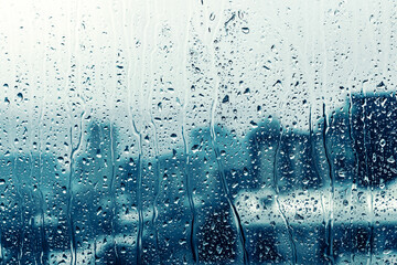 Naklejka na ściany i meble rain drop on window glass over blurred big city view
