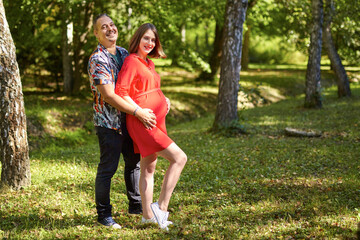 Fototapeta premium Lovely pregnant couple walking in a park