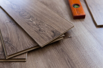 Installing laminated floor, detail on wooden tiles ready to be fit.