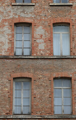 red bricks and old peeling windows of an old industrial building