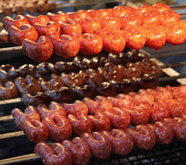 Sausages cooked on a spit over the glowing embers in the restaurant