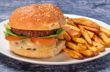 Beefburger in brioche burger bun with salad and chips