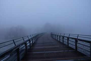 Wooden bridge disappears in thick fog