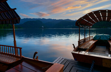 Traditional wooden pletna boats on Bled lake at sunset