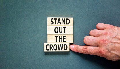 Stand out the crowd symbol. Concept words Stand out the crowd on wooden blocks on beautiful grey...