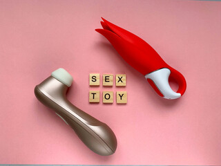 Sex toys. Two vibrators on a pink background. lettering SEX TOY. Useful for sex shop and  adults - obrazy, fototapety, plakaty