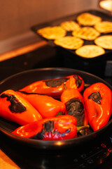 Homemade autumn vegetables recipes. Detail view with red hot capsicum pepper on a grill inside an apartment kitchen.