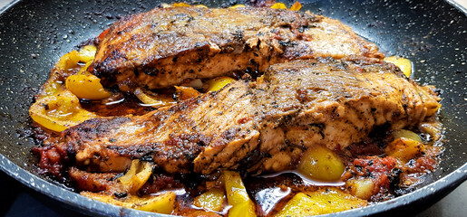 Spicy Salmon fish with fresh tomato, sweet red bell pepper and lemon cooked in frying pan