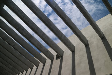 Underside of concrete walls and reinforced concrete beams structure with blue sky. Modern architecture. Minimalistic design