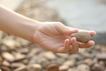 female hand holding small pebble stones picking up pebbles, round shape pebbles, summer vacation souvenir,