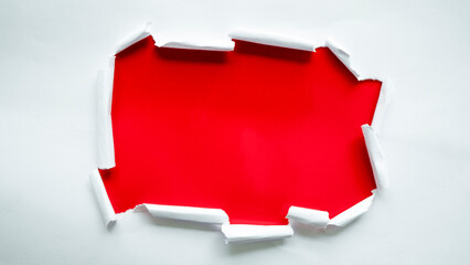 Torn white paper, breakthrough paper hole with red background.