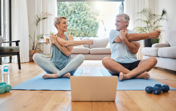 Stretching, happy morning and senior couple training with online workout in the living room of their house. Elderly man and woman doing warm up before fitness exercise with internet yoga on tech