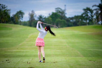 Professional woman golfer teeing golf in golf tournament competition at golf course for winner.	