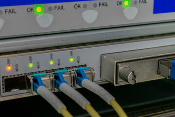 Fiber optic cable are connected to the interfaces of the central router. Modern equipment of the data processing center. Backbone high-speed Internet communication channel.