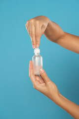 female hands holding bottle and pipette on background